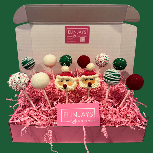 Box of cake pops with Santa hats on a green background